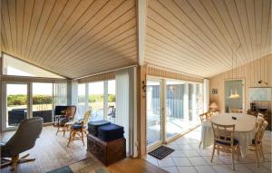 een woonkamer met een tafel en stoelen bij 4 Bedroom Beach Front Home In Ebeltoft in Ebeltoft