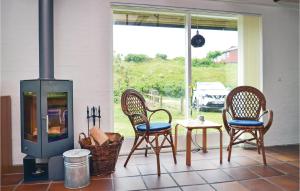 a porch with two chairs and a table and a stove at Holiday Home Lyngvej Fanø X in Fanø