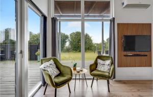 KnudにあるStunning Home In Haderslev With 4 Bedrooms, Sauna And Wifiのリビングルーム(椅子2脚、テーブル1台、テレビ付)