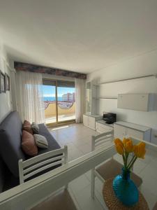 a living room with a couch and a vase with flowers at Alpen1 La Volta in Peñíscola