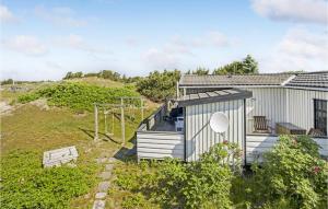 una pequeña casa en una colina con parque infantil en Stunning Home In Fan With Wifi, en Fanø