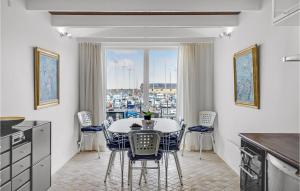 cocina con mesa, sillas y ventana en Nice Home In Glesborg With 1 Bedrooms And Wifi, en Bønnerup Strand