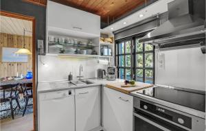 uma cozinha com armários brancos e uma bancada em Stunning Home In Fan With Wifi em Fanø