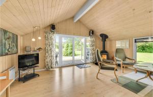 a living room with a flat screen tv and chairs at Amazing Home In Tarm With Wifi in Hemmet