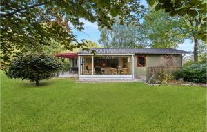 a small house with a lawn in front of it at Holiday Home Østersvej Glesborg X in Fjellerup Strand