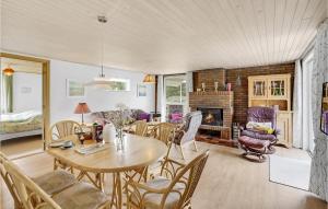 uma sala de estar com uma mesa e cadeiras e uma lareira em Cozy Home In Rm With Kitchen em Tagholm