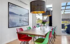 哈德斯萊夫的住宿－Pet Friendly Home In Haderslev With Kitchen，用餐室配有木桌和五颜六色的椅子