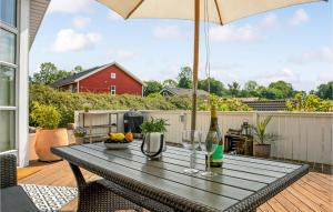 una mesa con copas de vino y una sombrilla en una terraza en Three-Bedroom Holiday Home In Aabenraa, en Aabenraa 19 fotos más