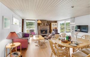 ein Wohnzimmer mit einem Tisch, Stühlen und einem Kamin in der Unterkunft Cozy Home In Rm With Kitchen in Tagholm