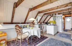Una cocina con mesa y sillas y un refrigerador. en Lovely Home In Rømø With Kitchen, en Tagholm