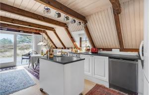 Una cocina con gabinetes blancos y una ventana grande. en Lovely Home In Rømø With Kitchen, en Tagholm