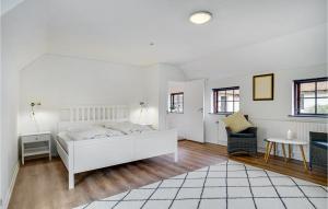 ニュークビン・シェランにあるAmazing Home In Nykbing Sj With 4 Bedrooms, Wifi And Saunaの白いベッドルーム(ベッド1台、椅子付)