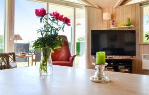 EskebjergにあるAmazing Home In Eskebjerg With 3 Bedrooms, Sauna And Wifiのリビングルームのテーブルに飾られた花瓶