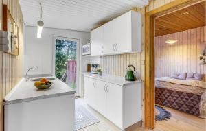 una cocina con armarios blancos y una cama en una habitación en Gorgeous Home In Rm With Wifi, en Rømø Kirkeby