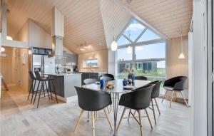 uma cozinha e sala de jantar com mesa e cadeiras em Stunning Home In Hvide Sande With House A Panoramic View em Havrvig