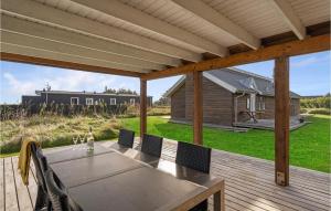 eine Terrasse mit einem Tisch und Stühlen auf einer Terrasse in der Unterkunft Stunning Home In Hvide Sande With House A Panoramic View in Havrvig