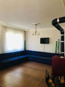 un salon avec un canapé bleu et une télévision dans l'établissement Chalet 20 Min Far To Uludag Ski Resort, à Çekirge