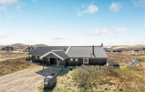 a black house on a hill with a yard at Cozy Home In Hvide Sande With Wifi in Havrvig