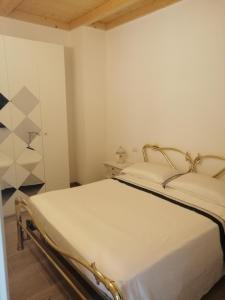 1 dormitorio con 1 cama con sábanas blancas en La casa di Antonella en Vico del Gargano