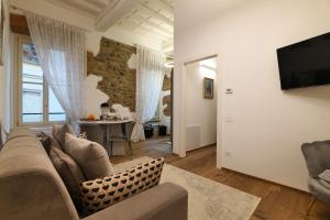 ein Wohnzimmer mit einem Sofa und einem TV in der Unterkunft Appartamenti Villa Casati 1p in Casatenovo