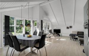 a dining room and living room with a table and chairs at Holiday Home Søknudevej Ansager Denm in Ansager