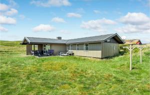 BjerregårdにあるStunning Home In Hvide Sande With Saunaの草原のある丘の上の家