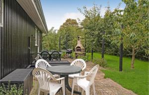 a patio with a table and chairs and a grill at Stunning Home In Assens With Kitchen in Assens