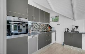 a kitchen with stainless steel appliances and gray cabinets at Holiday Home Søknudevej Ansager Denm in Ansager +10 photos