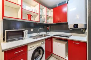 a kitchen with red cabinets and a washing machine at SANTA PAULA CENTRO JUNTO CATEDRAL center in Granada