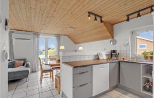 Amazing Home In Vinderup With 4 Bedrooms, Wifi And Indoor Swimming Pool في Vinderup: مطبخ بدولاب بيضاء وسقف خشبي