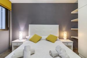 a bedroom with a large white bed with two yellow pillows at SANTA PAULA CENTRO JUNTO CATEDRAL center in Granada