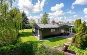 a small green cabin in a field with trees at Stunning Home In Hejls With 3 Bedrooms And Wifi in Hejls