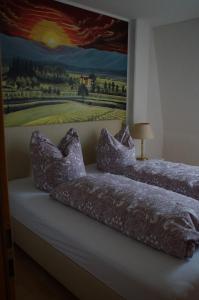 two beds in a room with a painting on the wall at Ferienwohnung Castellberg in Heitersheim