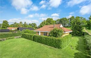 una casa con un seto delante de un patio en Gorgeous Home In Hejls With Kitchen, en Hejls