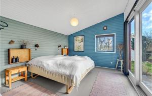 a blue bedroom with a bed and a window at Awesome Home In Mesinge With Wifi in Mesinge +15 photos
