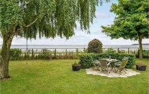 a patio with a table and chairs in a yard at Awesome Home In Skrup Fyn With House A Panoramic View in Skårupøre
