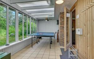 eine Tischtennisplatte in einem Raum mit Fenstern in der Unterkunft Three-Bedroom Holiday Home In Martofte in Martofte