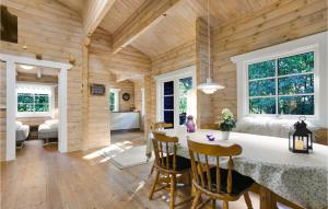a log home kitchen and dining room with a table and chairs at Holiday Home Holmegårdsvej Rønne V in Hasle