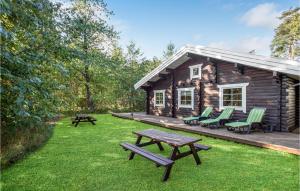 Cabaña de madera con mesa de picnic y sillas en Stunning Home In Rnne With Wifi, en Hasle
