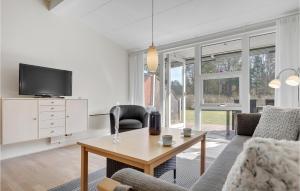 a living room with a couch and a table at Awesome Apartment In Nex With Sauna, Wifi And Indoor Swimming Pool in Strandby Gårde