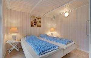 a bedroom with two beds with blue pillows on them at Cozy Home In Rdby With Sauna in Kramnitse