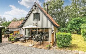 a house with a deck with a table and chairs at Holiday Home Vestre Strandvej Nexø Iii in Balke +16 photos