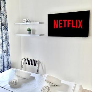 a bedroom with a bed with a netflix sign on the wall at Angelina's Lovely Home in Iraklitsa