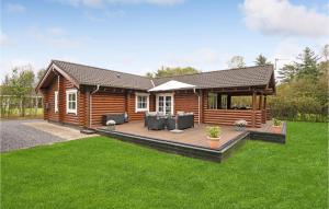 ein Blockhaus mit einer Terrasse im Hof in der Unterkunft 3 Bedroom Amazing Home In Fars in Hvalpsund