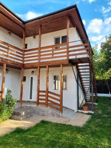 dom z drewnianym dachem i schodami w obiekcie Casa Dada w mieście 2 Mai