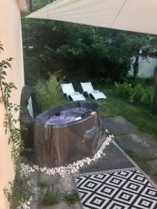 een achtertuin met een hot tub en 2 witte banken bij Fecske Family Jakuzzi House_65m Lake-5 Bedroom in Zamárdi