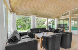 a living room with black leather furniture and a table at Stunning Home In Vggerlse With Sauna, Wifi And Indoor Swimming Pool in Bøtø By