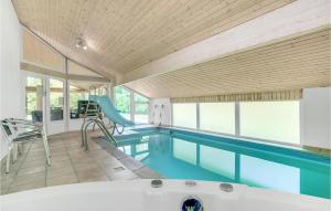 a large swimming pool with a tub in a house at Stunning Home In Vggerlse With Sauna, Wifi And Indoor Swimming Pool in Bøtø By