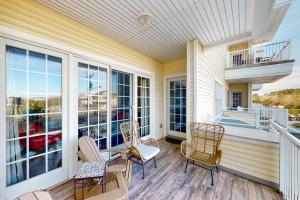 une terrasse couverte avec des chaises et une table ainsi qu'un balcon dans l'établissement The Sandbridge Dunes - A Beach Delight 116, à Virginia Beach