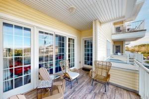 a porch with chairs and a table and a balcony at The Sandbridge Dunes - A Beach Delight 116 in Virginia Beach
